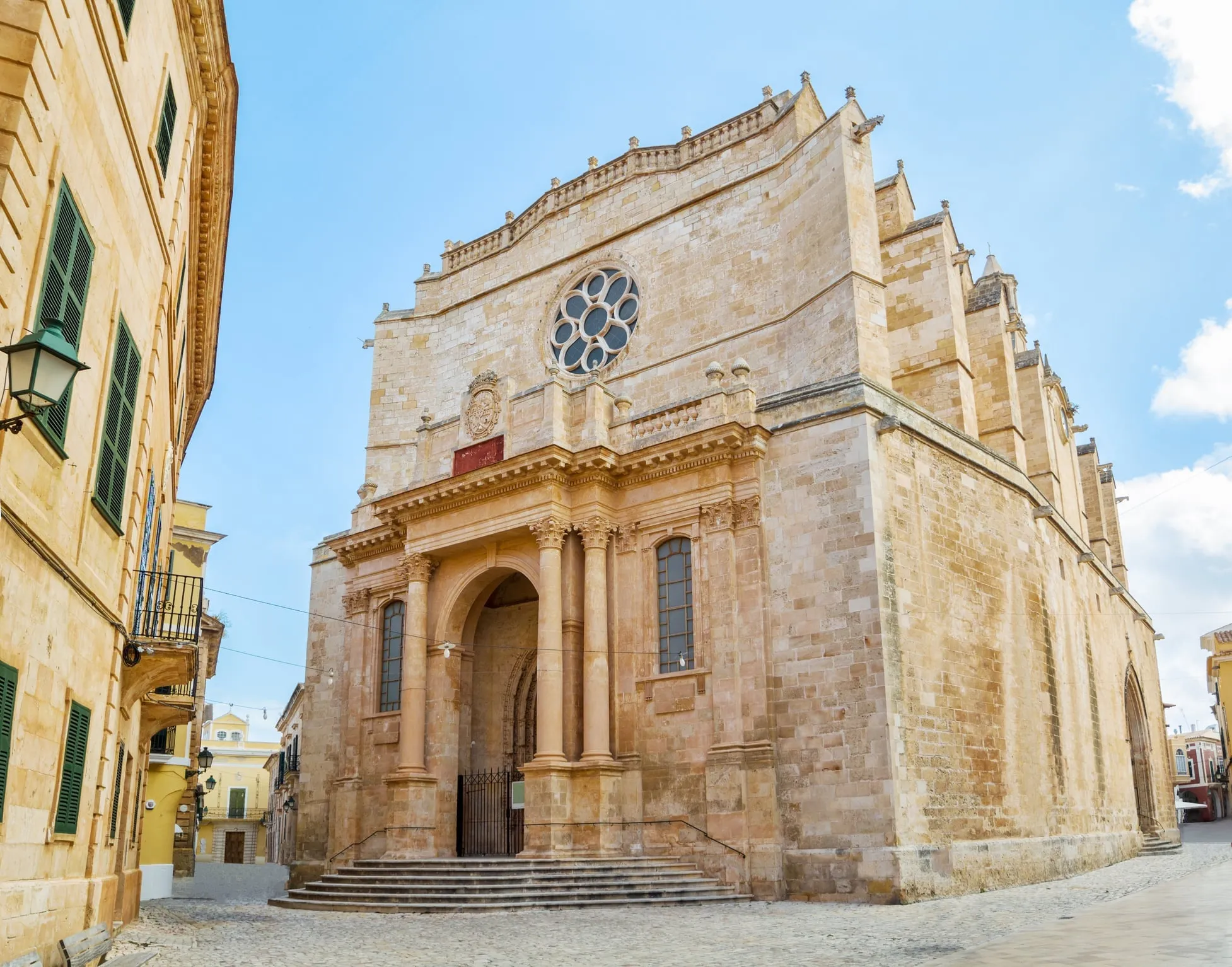 Gothic facade of Ciutadella Cathedral rising above the narrow streets, built on layers of religious history from Talayotic sanctuary to mosque to church