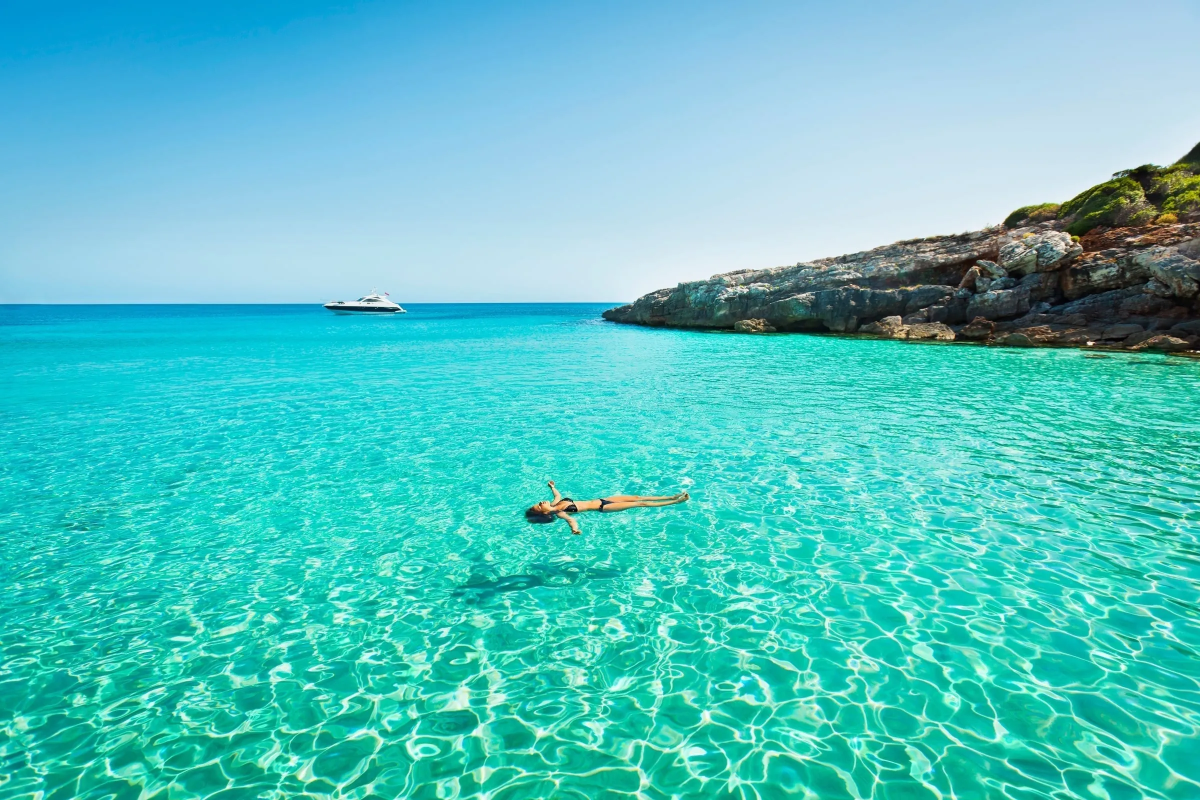 Person floating in the clear blue waters off Menorca's coast